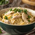 creamy crockpot chicken pasta served in a white bowl with parsley garnish